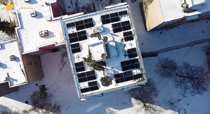 Pohled shora na nainstalované solární panely na bytovém domě.